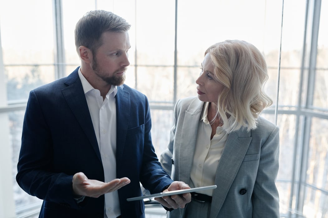 A Man Holding a Tablet While Communicating with a Woman